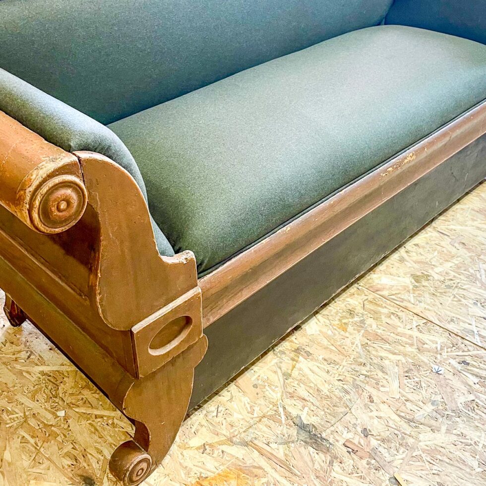 Historisk trebenk med grønt stoffsete