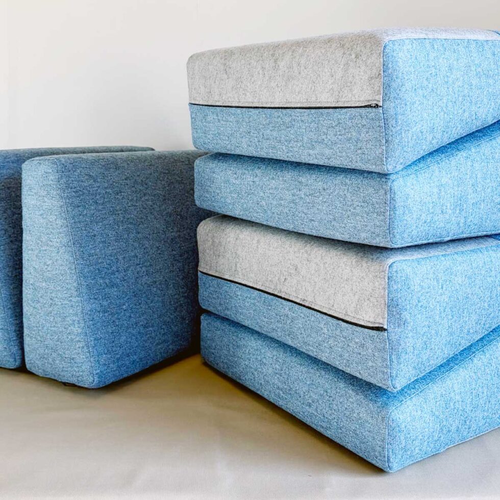 nærbilde av forskjellige sofaputer i blått trekk